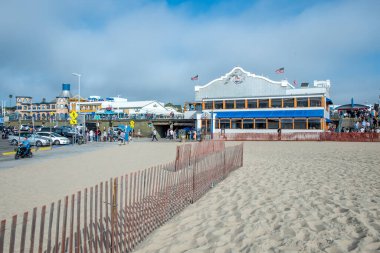 Santa Monica, ABD - 25 Nisan 2019: Santa Monica Pier Ferris Wheel, Kaliforniya 'da plajın keyfini çıkaran insanlar.