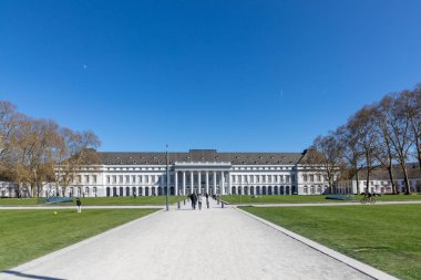 Koblenz, Almanya - 6 Nisan 2025: güneşli bir günde insanların önündeki yeşil çimlerin tadını çıkardıkları Koblenz kalesine bakın.