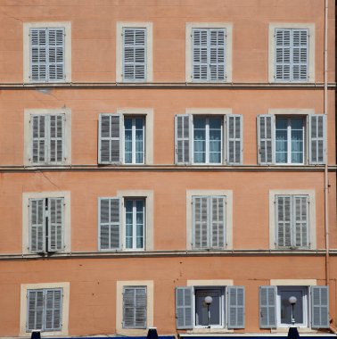 Geleneksel tarzda açık ve kapalı panjurları olan eski bir otelin tipik dış görünüşü