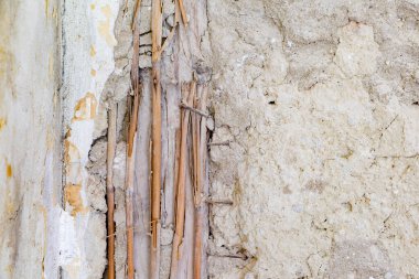 Hasarlı eski ringa kemiği parketinin arka planı. Hasarlı durumdaki tarihi duvarın ayrıntıları. Tahtaya saman çivilenmiş ve duvarda kırık alçı var.