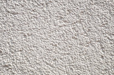 Beyaz alçı duvar deseni harmonik bir arkaplan verir