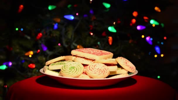 圣诞树前的一盘甜饼干 上面闪烁着五彩缤纷的彩灯 — 图库视频影像