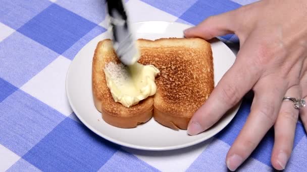 餐厅的一位顾客在她刚烤好的早餐吐司上涂了奶油 — 图库视频影像