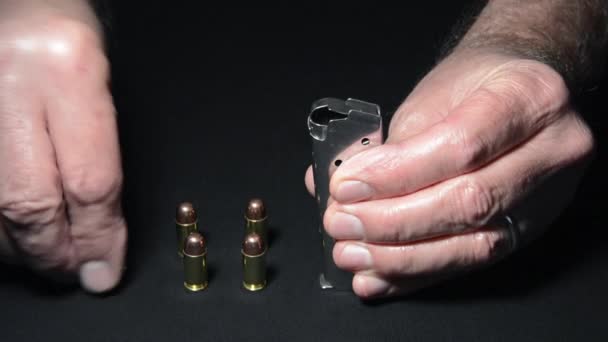 銃に銃を装填する前に銃の雑誌に弾丸を挿入する男 — ストック動画