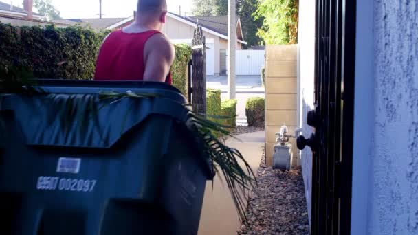 Man Rolls His Green Trash Can Side Yard Walkway Sidewalk — Stock Video