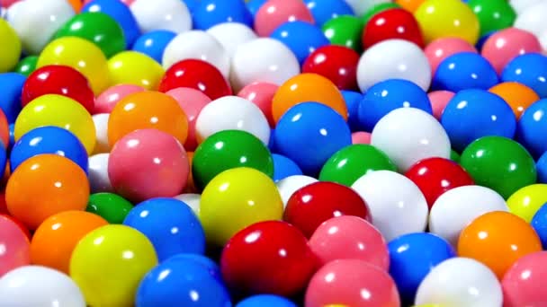 さまざまな明るい色の甘いキャンディーガムボールの回転ボウルは 楽しい背景やスクリーンセーバーとして使用できます — ストック動画