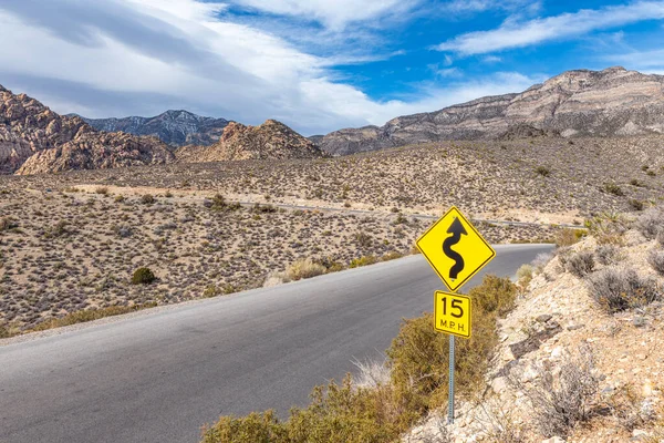 ネバダ州ラスベガスのレッドロックキャニオン保全荒野の曲がりくねった道に沿った警告サイン — ストック写真