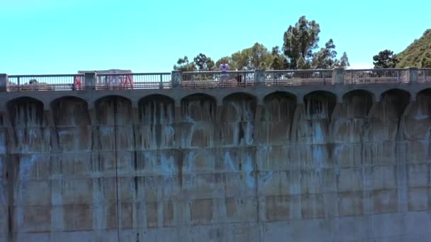 1924年由Mulholland Dam建造的好莱坞湖水库的无人机图像被一条供骑单车 慢跑和步行的娱乐小径所环绕 大坝本身提供了这一地区唯一畅通无阻的景观 — 图库视频影像