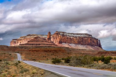 A beautiful snowcapped mountain range along highway 163 in Monument Valley highlights the beautiful, rugged scenery for tourists to enjoy.   clipart