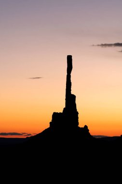 Sunrise behind Monument Valley's famous totem pole and nearby spires, all formed by millions of years of erosion from wind and rain.. clipart