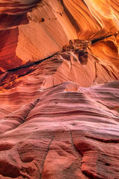 アリゾナ州のスロットキャニオンの砂岩の壁の渦巻きパターンは 柔らかい岩の組成による風と水の流れパターンの年から形成されます ストック写真