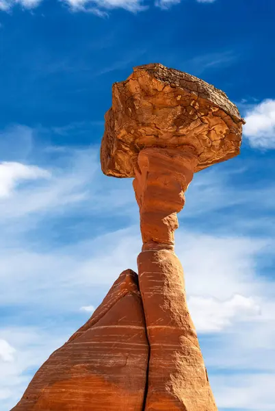 stock image White and red sandstone toadstool hoodoo at Kanab Utah showing highly eroded spires and balanced harder rock on top framed by a blue sky.