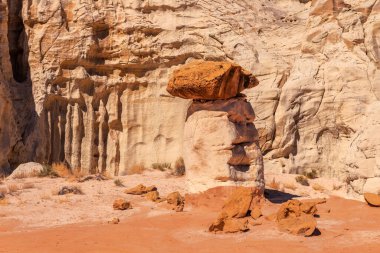 White and red sandstone toadstool hoodoo at Kanab Utah showing highly eroded spires and balanced harder rock on top. clipart