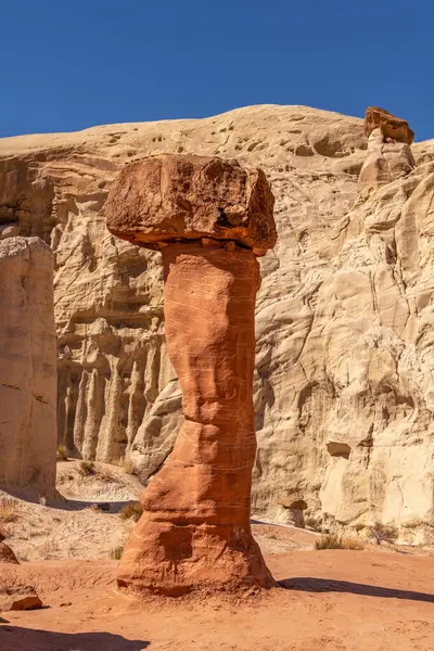 stock image White and red sandstone toadstool hoodoo at Kanab Utah showing highly eroded spires and balanced harder rock on top framed by a blue sky.