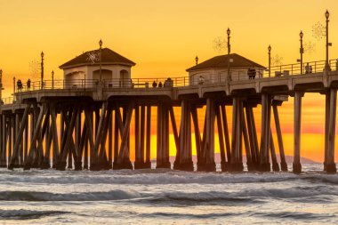 Dramatic sky from wildfire smoke surrounds the pier in Huntington beach California, providing a unique sunset of the iconic destination. clipart