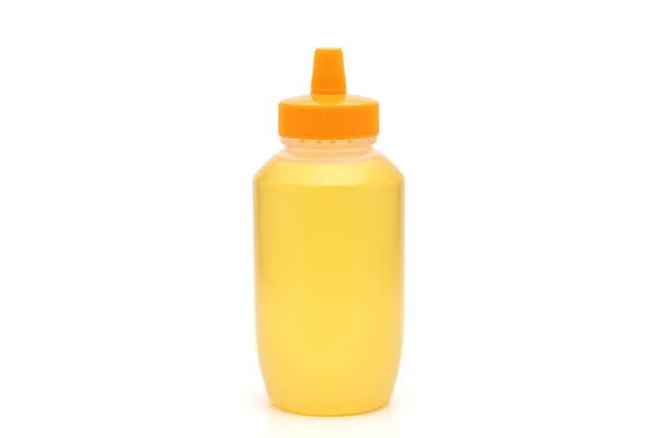 蜂蜜在白色背景上的塑料瓶 — 图库照片