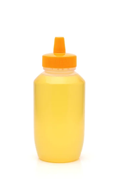 白い背景の上に蜂蜜のプラスチック製のボトル — ストック写真