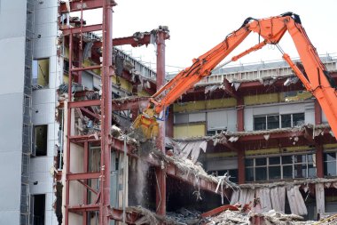 Bina yıkım işi. Ağır inşaat ekipmanları.