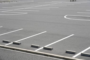 Asfaltlanmış park yerinde yol izleri var.                                