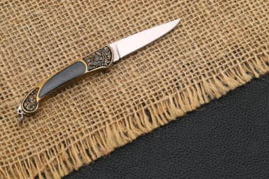 Kenevir bezi arka planında küçük katlanan bıçağın fotoğrafını kapat 