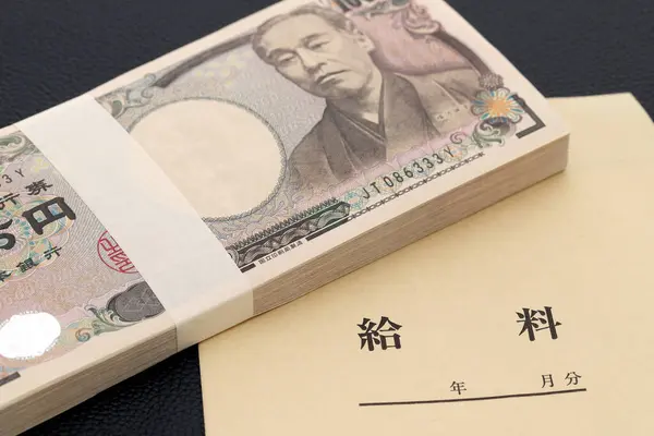 Japanische Zehntausend Yen Einer Lohntüte Auf Schwarzem Hintergrund Übersetzung Gehalt lizenzfreie Stockbilder