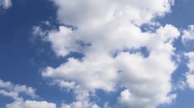 Mavi gökyüzünde beyaz kaynayan bulutlarla hareket, zaman akışı.