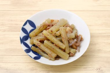 Japanese boiled butterbur in plate on table background  clipart