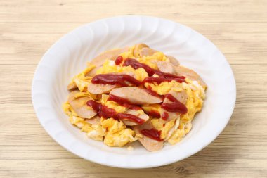 Arka planda tabakta kızarmış balık sosisi ve yumurta. 