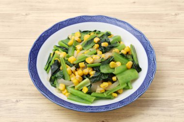 Mısır ve Japon Komatsuna tabakta sebze kızartması bırakır.