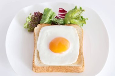 Kahvaltıda kızarmış yumurtalı kızarmış ekmek, beyaz arka planda.  