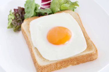 Kahvaltıda kızarmış yumurtalı kızarmış ekmek, beyaz arka planda.  