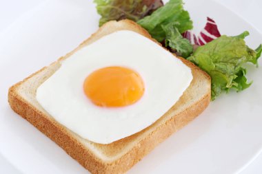 Kahvaltıda kızarmış yumurtalı kızarmış ekmek, beyaz arka planda.  