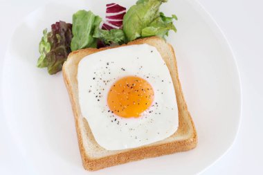 Kahvaltıda kızarmış yumurtalı kızarmış ekmek, beyaz arka planda.  