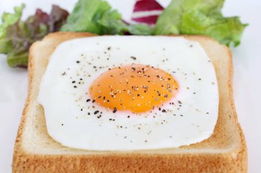 Kahvaltıda kızarmış yumurtalı kızarmış ekmek, beyaz arka planda.  