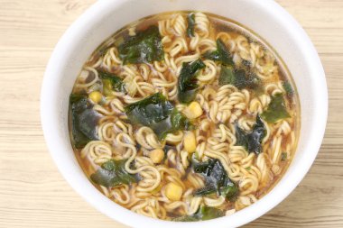 Boiled instant plastic cup noodles on table background