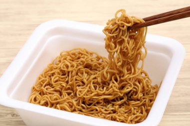 Beyaz plastik bir fincanda Japon Yakisoba 'sında anında kızarmış şehriye.. 