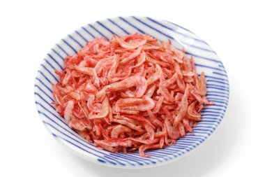 Beyaz arkaplanda servis edilen kurutulmuş küçük karidesler. 