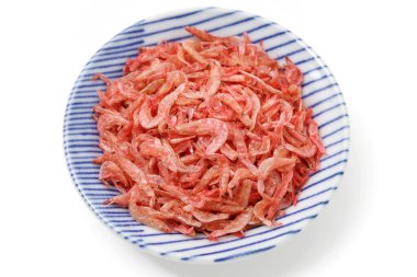 Üst görünüm beyaz zemin üzerinde servis edilen küçük karidesler