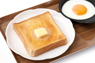 Masada dilimlenmiş ekmek ve erimiş tereyağı. 