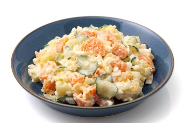 Beyaz arka planda bir tabakta Japon patates salatası. 