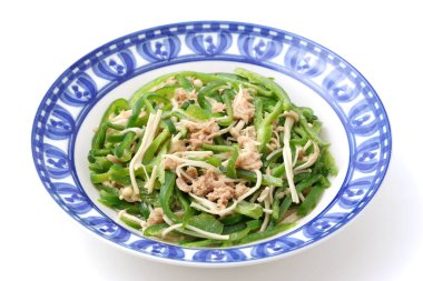 Yeşil biberli sebze ve Enoki mantarı beyaz arka planda bir tabakta kızartılır.