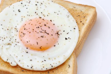 Kahvaltı için tost ekmeği ve beyaz arka planda biberli kızarmış yumurta.