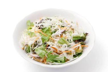 Beyaz arka planda karışık sebze salatası. 