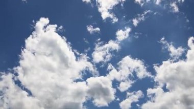 Mavi gökyüzünde beyaz kaynayan bulutlarla hareket, zaman akışı. 