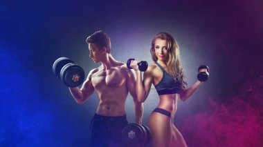  Athletic man and woman with a dumbells showing muscles. Neon light. clipart