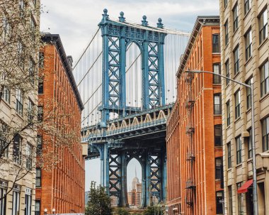  Brooklyn, New York. Manhattan ve Brooklyn arasındaki Manhattan Köprüsü Doğu Nehri üzerinde iki tuğla bina tarafından çevrelenmiş dar bir geçitten görülüyor..