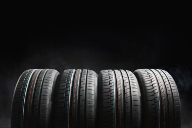 Araba tamirhanesinde harika profilli araba lastikleri. Beyazların önündeki yaz ya da kış lastikleri.