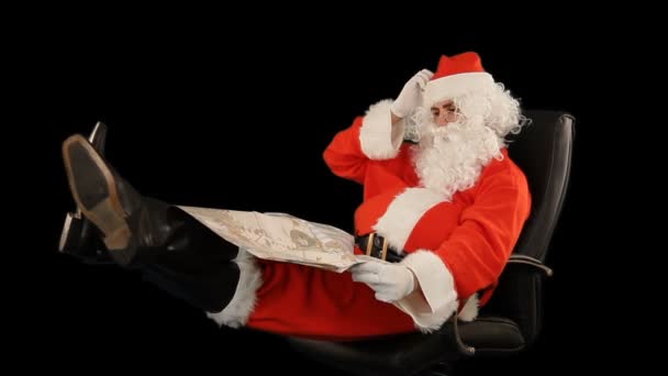 圣诞老人坐在皮椅上 看着地图上的黑人 — 图库视频影像