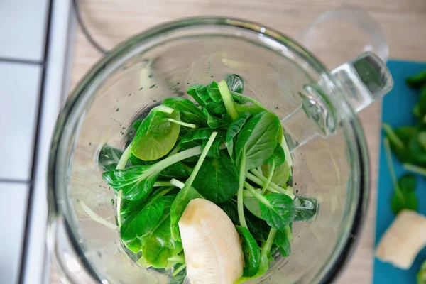 Top view of ingredients for healthy green smoothie in blender. Diet, healthy eating, vegan food