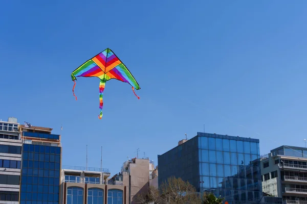 Renkli uçurtma gökyüzünde yükseliyor Mavi gökyüzü. Spor uçurtma festivali. Yunanistan 'da temiz bir pazartesi. Kıvrılan kuyruklu uçan bir uçurtma. Kopyalama alanı